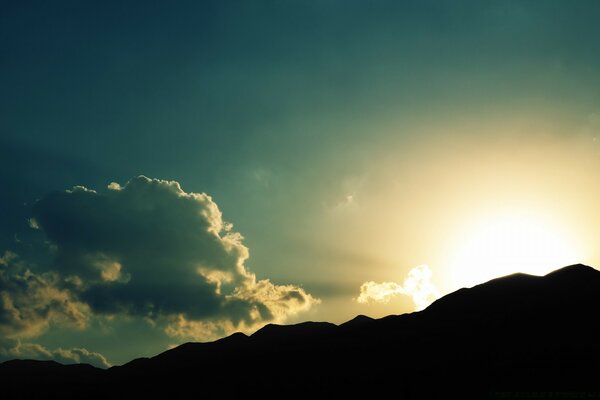 Silueta de montaña y sol saliente