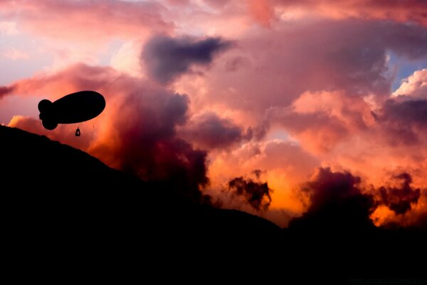 The balloon flies into a red sunset with clouds