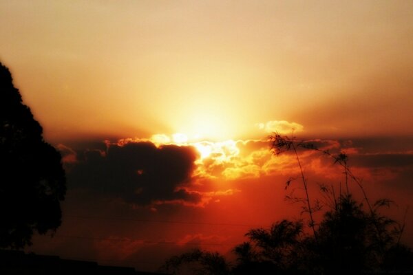 Feuriger Sonnenuntergang hinter flauschigen Wolken