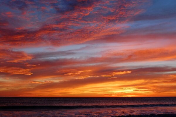 Hermosa puesta de sol del mar con nubes iluminadas