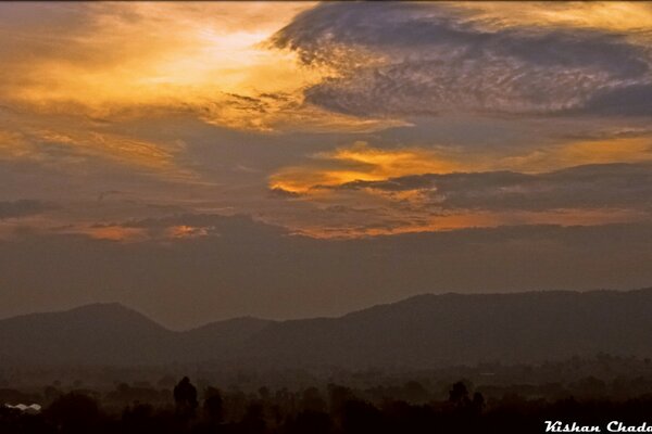 Landschaft mit blitzendem Himmel und Bergen bei Sonnenuntergang