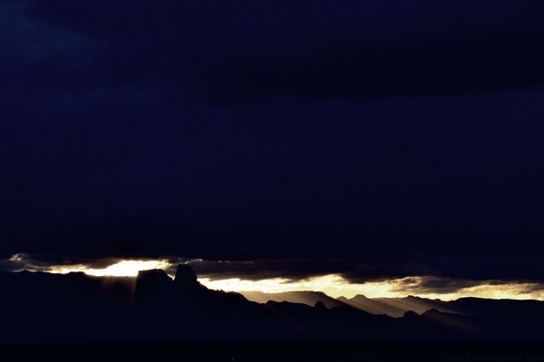 Himmlischer Schlitz mit Sonnenlicht zwischen schwarzen Wolken während eines Sturms