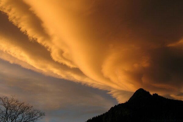 Silhouette of a mountain under a cloudy sky