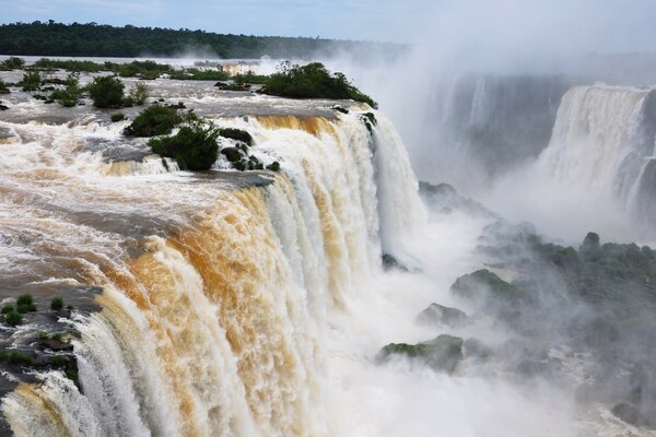 Landscape of a high waterfall on the background of a wild forest