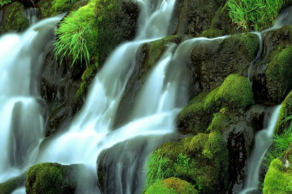 A mountain waterfall surrounded by greenery