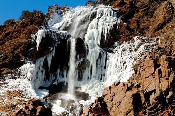 Una forte cascata tempestosa scende lungo la roccia