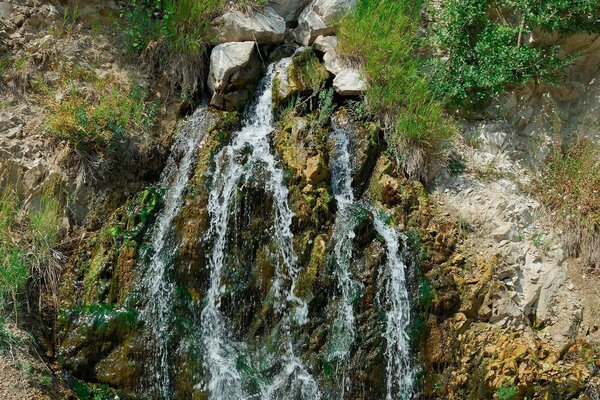 منظر طبيعي جميل مع شلال بالقرب من الصخور