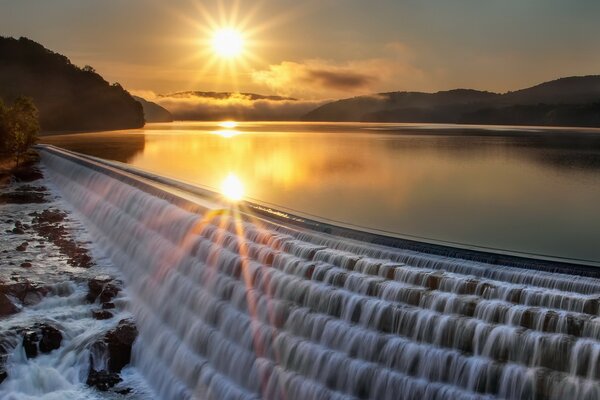 Blendung der Sonne auf einer glatten Wasseroberfläche