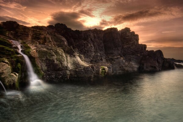 Cascada en el fondo de una hermosa puesta de sol