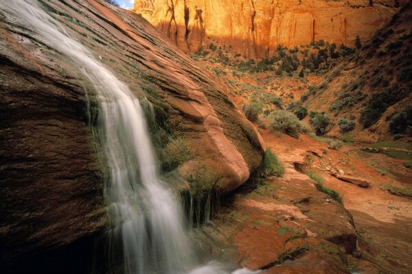 Waterfall on the background of rocks and river