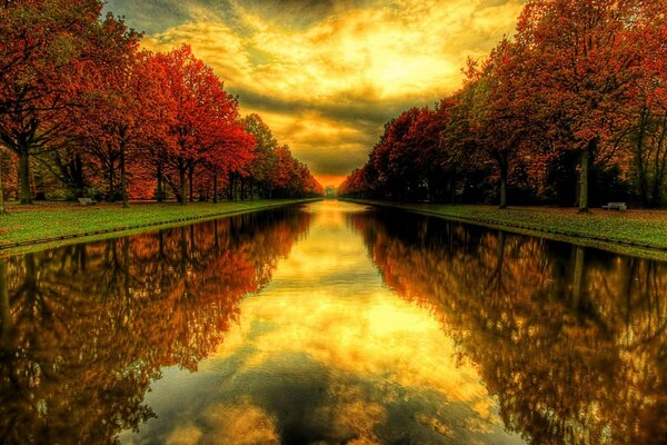 The reflection of the sky in the water in the autumn park