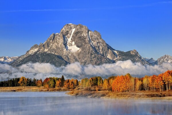 Alta montagna sullo sfondo del lago e della foresta