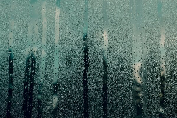 Gouttes de pluie sur le verre embué