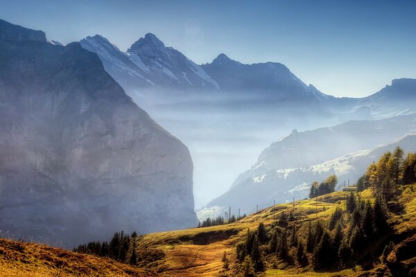 Le grandi montagne si ergono sopra la pianura, il paesaggio con una forza straordinaria si schianta dal cielo alla terra, il viaggio fa cenno