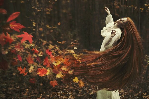 Ein Mädchen mit roten Haaren, ein Haarfleck aus hellen Herbstblättern