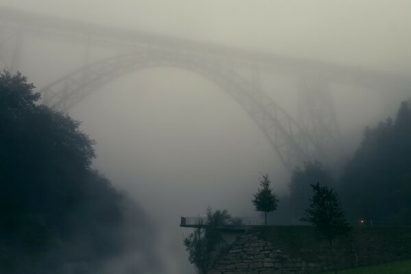 A bridge in the fog at dawn. Landscape