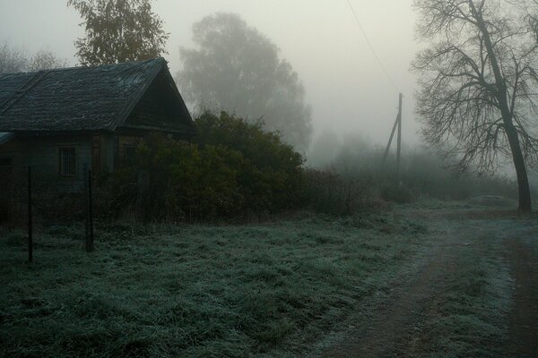 Un camino de niebla con una casa antigua