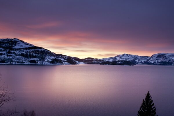 La surface du lac sur fond de montagnes enneigées