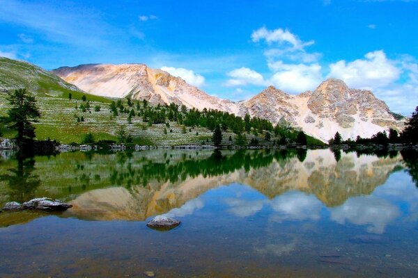 झील के दर्पण पर पहाड़ों का प्रतिबिंब