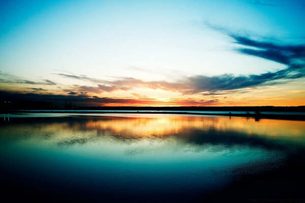 Anochecer junto al agua. Puesta de sol en el mar. Puesta de sol roja