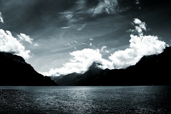 Black and white nature by the water. Clouds over the water