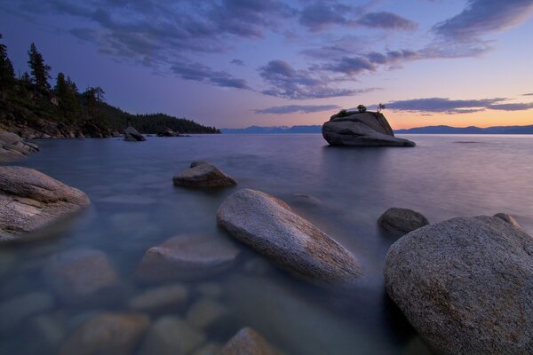 Costa rocosa del mar. Crepúsculo. Puesta de sol junto al agua