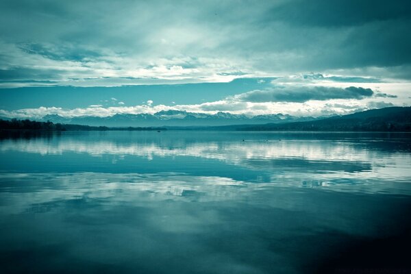 Riflesso del cielo e delle nuvole in un lago limpido