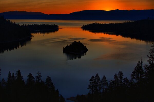 Orange sunset in the forest by the lake