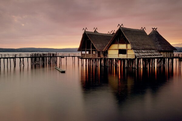 Reflexion von Häusern und Pier im Wasser