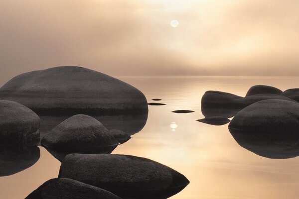 Grey lake with big rocks