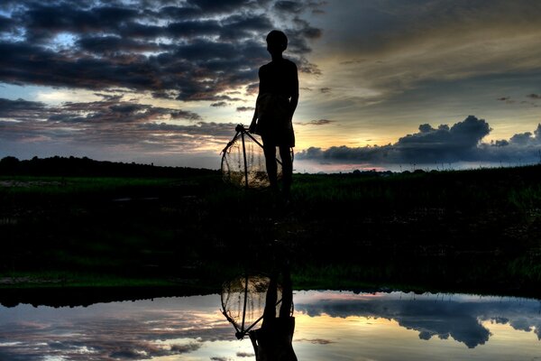 Uomo al tramonto vicino all acqua