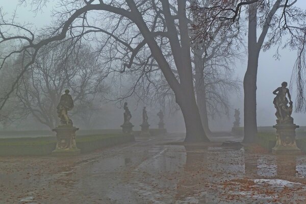 Parque de niebla de otoño con estatuas