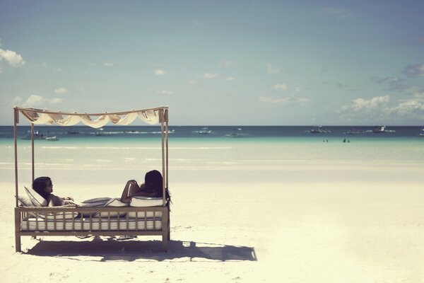 Dos chicas tomando el sol en la playa