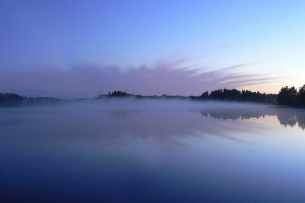 Blue sunset over the lake. Twilight by the water