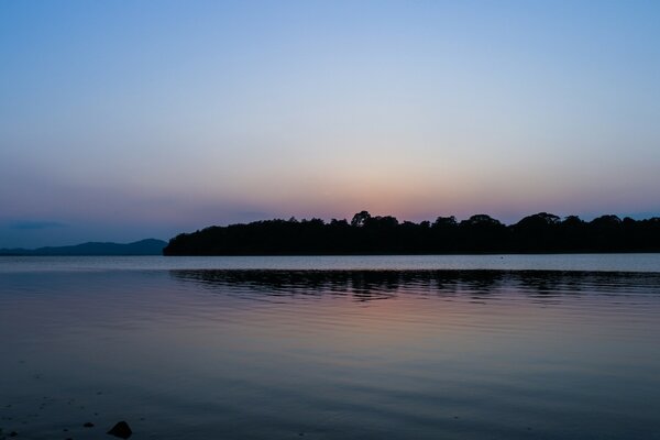 Schöner Sonnenuntergang am Wasser mit Sonneneinstrahlung