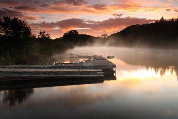 Pier on the lake in the misty dawn