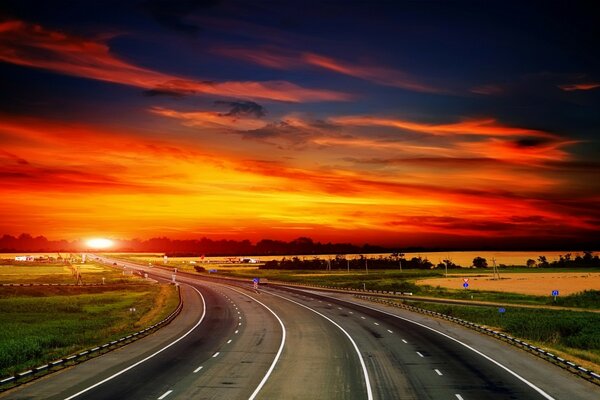 Camino vacío en el fondo de una hermosa puesta de sol