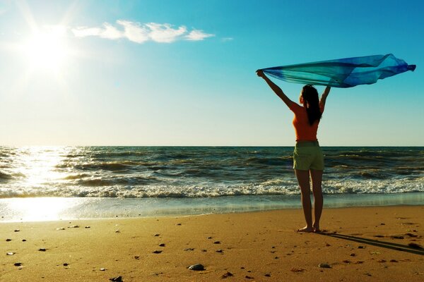 A girl with a pareo on the beach. Yellow sand and sunrise