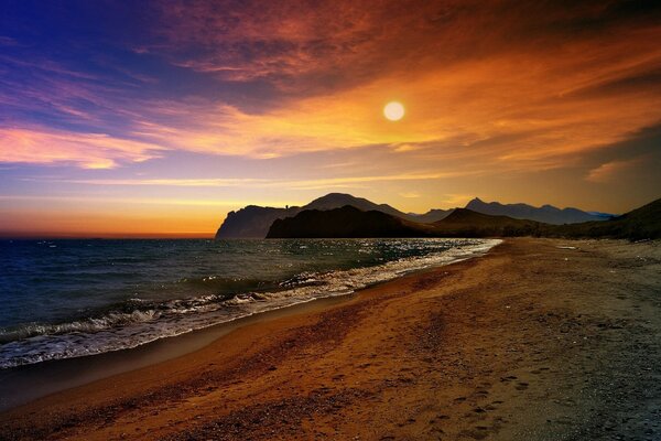 Puesta de sol nublada en la orilla del mar