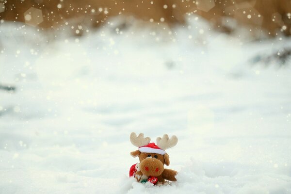 Stofftier Elch sitzt im Schnee