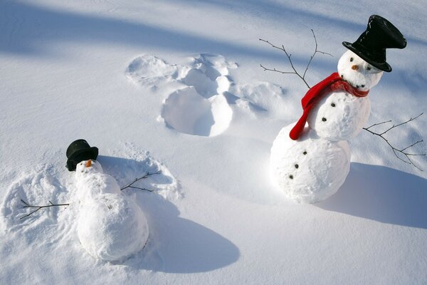 Dos muñecos de nieve con sombreros negros