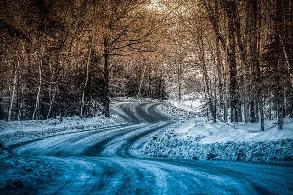 Frostige Winterstraße im Wald