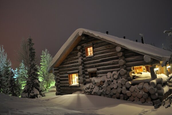 Light in the window of a snow-covered house