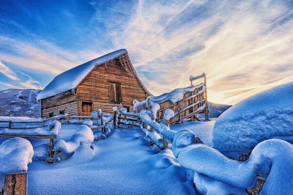 Winterlandschaft. Holzhaus mit Zaun