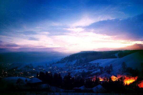 Amanecer en la ciudad entre las montañas cubiertas de nieve