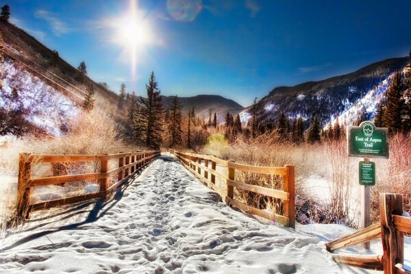 一条被篱笆围起来的山中白雪复盖的道路