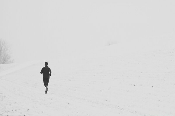 Ein Mann, der auf einer verschneiten Straße läuft