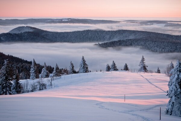 Wanderweg vor dem Hintergrund eines verschneiten Sonnenuntergangs