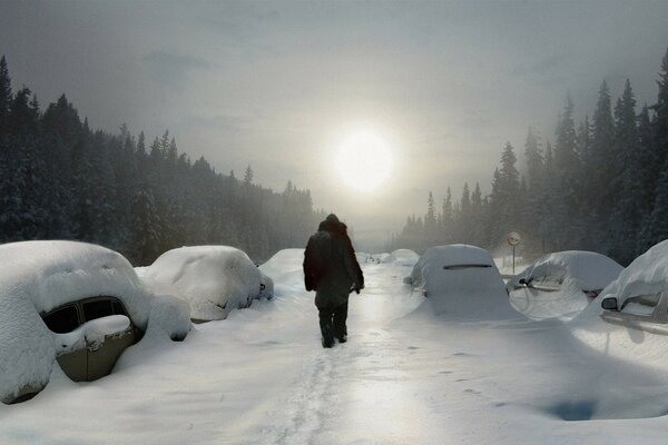 Hombre en el camino de invierno hacia el sol