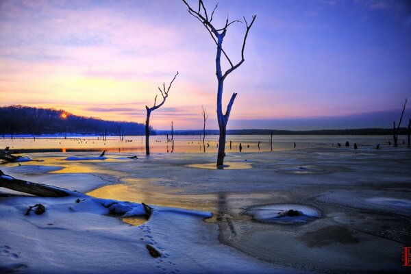 Sonnenuntergang oder Sonnenaufgang im Winter am Strand und die Reflexion der Sonne im Wasser